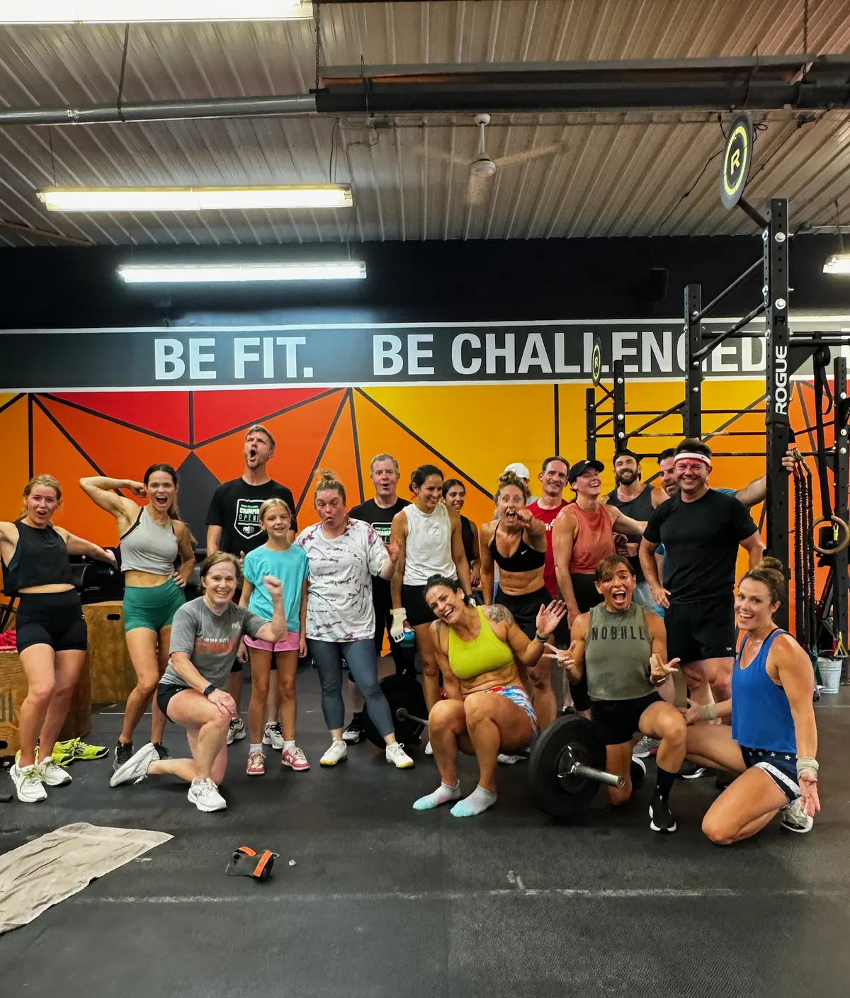 Pro-Fit members gathered under the Be Fit. Be Challenged. mural after a class
