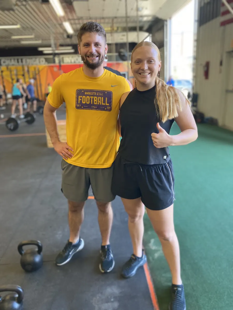 Two smiling members on the training floor after class